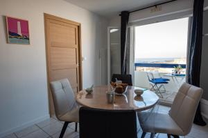 uma sala de jantar com uma mesa e vista para o oceano em Charmant appartement avec vue imprenable sur la mer em Les Sables-dʼOlonne