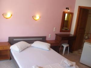 a bedroom with a bed and a dresser and a mirror at SKIATHOS STUDIOS in Skiathos Town +66 photos