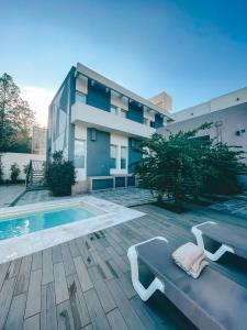 圣洛伦索SIETE LUNAS DE San Lorenzo的一座带游泳池和长凳的建筑,毗邻一座建筑