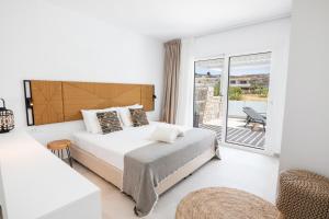 a bedroom with a bed and a balcony at Alkithea luxury suites in Karpathos Town +41 photos