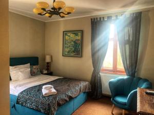 1 dormitorio con cama, silla azul y ventana en Leniwka, en Świebodzin