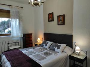 1 dormitorio con 1 cama grande con sábanas blancas en Apartamento Maribel, en Biescas