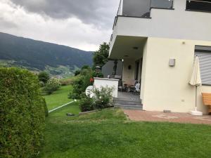 uma casa branca com um pátio e um relvado em Ferienwohnung Reinstadler Ilse em Jerzens