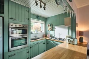 a kitchen with green cabinets and a wooden counter top at The Moorings, overlooking Loch Fyne in Cairndow