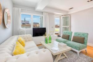 - un salon avec un canapé blanc et deux chaises dans l'établissement iloftmalaga Deluxe Calle Nueva III, à Malaga