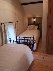 a bedroom with two beds and a window at Pentwyn Barn in Brynamman