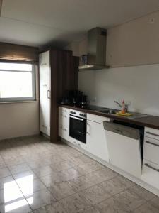 Una cocina con gabinetes blancos y un horno de estufa. en Kleine Perle, Villa Sonnegarten, en Boltenhagen