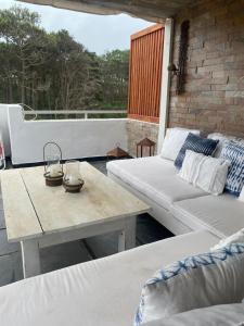 a patio with a couch and a coffee table at Arenas Garzón A 8 in José Ignacio +8 photos