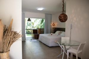 a bedroom with a bed and a glass table at Villas Supreme Hotel in Maceió