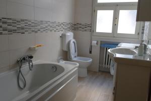 ein Badezimmer mit einer Badewanne, einem WC und einem Waschbecken in der Unterkunft Apartment Podgora 13 in Mestre