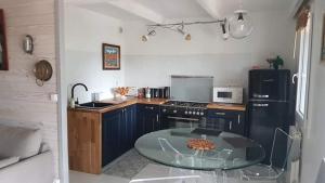 a kitchen with a glass table in a kitchen at La cabane du pêcheur in Mèze