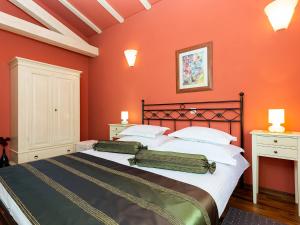 a bedroom with a large bed with orange walls at Villa Salvea with heated pool in Montižana +55 photos