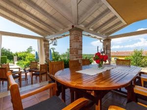 a wooden table and chairs on a patio at Villa Salvea with heated pool in Montižana