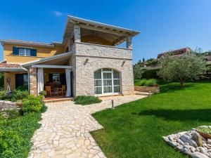 una casa con un camino de piedra delante de ella en Villa Salvea with heated pool, en Montižana
