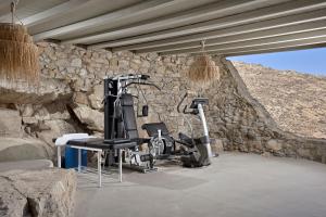 un gimnasio con pared de piedra y equipamiento de ejercicio en Villa Serenity, en Mykonos ciudad