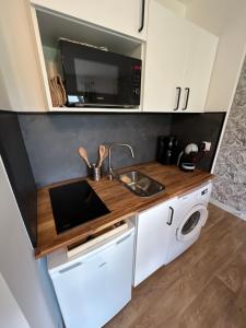 a small kitchen with a sink and a microwave at Explorer in Betton