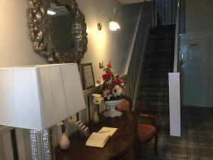 a room with a table with a mirror and a staircase at The Benson Hotel in Blackpool