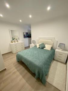 um quarto com uma cama com um cobertor verde em Monte Gordo apartment em Monte Gordo