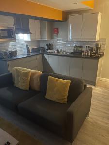 uma sala de estar com um sofá na cozinha em 42 Apart-Hotel em Scunthorpe
