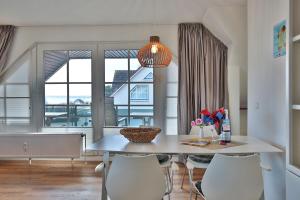 a dining room with a table and chairs and a large window at Ostseeblick Ostseeblick Appartement 19 in Scharbeutz