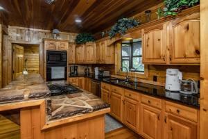 a kitchen with wooden cabinets and black counter tops at River Wellness Lodge in Kingston