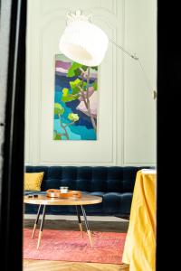 a living room with a blue couch and a coffee table at Le Henri IV in Le Mans