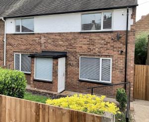 a brick house with a fence in front of it at NEW Luxurious Modern Large 3 Bed House - Sleeps Up to 10 Guests - Sky Ultra HD, Sky Movies, Netflix, Disney Plus in Mansfield