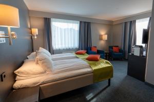 Una habitación de hotel con una cama y una sala de estar. en Thon Partner Hotel Måløy, en Måløy