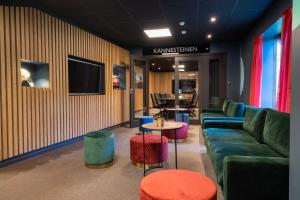 a living room with a couch and a table at Thon Hotel Måløy in Måløy +19 photos