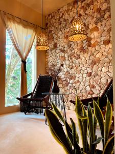a living room with a stone wall and two lights at Hotel Boutique Refugio 41 in Valladolid