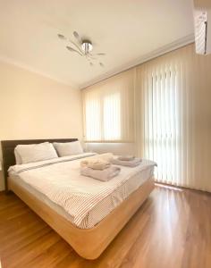 a bedroom with a bed with white sheets and a ceiling at Etica Apartments in Plovdiv