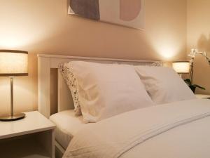 1 dormitorio con 1 cama con sábanas blancas y lámpara en FilinHome Papa Suite 3, en Novi Sad