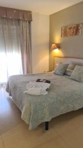 a bedroom with a bed with towels on it at Hotel Cosmos Tarragona in Tarragona
