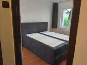 - un petit lit dans une chambre avec fenêtre dans l'établissement Apartment Ploiesti, à Ploieşti