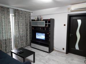 a living room with a flat screen tv on a entertainment center at Apartment Ploiesti in Ploieşti