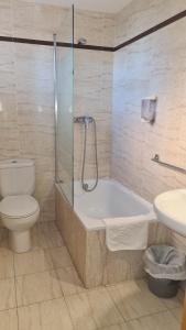a bathroom with a tub and a toilet and a sink at Hotel Cosmos Tarragona in Tarragona