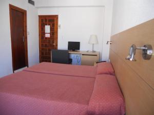 En eller flere senge i et værelse på Hotel Sacratif