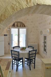 een keuken met een tafel en stoelen in een kamer bij I Trulli del Tempo in Martina Franca