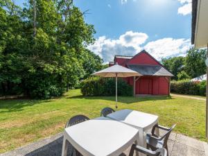 stół z parasolem obok dziedzińca w obiekcie Holiday Home Cottage Confort 5 Pers- by Interhome w mieście Saumur