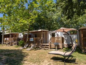 a group of mobile homes in a yard with a swing at Holiday Home Camping La Masseria-2 by Interhome in Il Monte