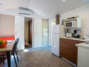 a kitchen with a white refrigerator and a table at Holiday Home Camping La Masseria-2 by Interhome in Il Monte +39 photos