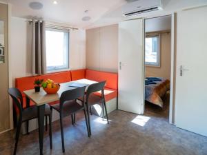 a dining room with a table and chairs and a bed at Holiday Home Camping La Masseria-2 by Interhome in Il Monte