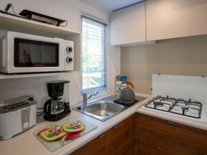 a kitchen with a sink and a microwave at Holiday Home Camping La Masseria-2 by Interhome in Il Monte