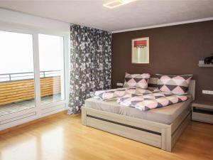 sypialnia z łóżkiem i dużym oknem w obiekcie Apartment Aktiv-3 by Interhome w mieście Huben