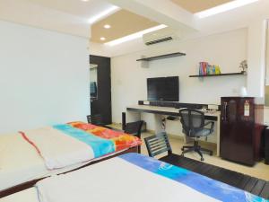 1 dormitorio con 1 cama y escritorio con ordenador en Apartment In Mumbai City Centre en Bombay