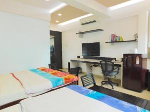 a bedroom with a bed and a desk with a computer at Apartment In Mumbai City Centre in Mumbai