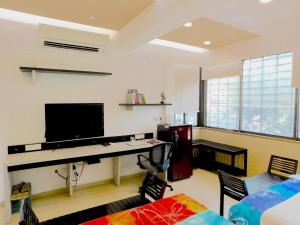 a living room with a desk and a television at Apartment In Mumbai City Centre in Mumbai