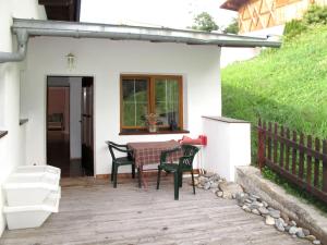 patio ze stołem i krzesłami przed domem w obiekcie Apartment Aktiv-2 by Interhome w mieście Huben