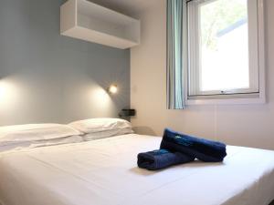 białe łóżko z niebieską torbą. w obiekcie Holiday Home Eden-2 by Interhome w mieście San Felice del Benaco +29 zdjęć