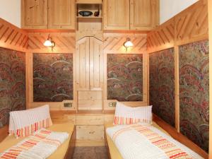 dwa łóżka w pokoju z drewnianymi ścianami w obiekcie Apartment Aktiv-2 by Interhome w mieście Huben